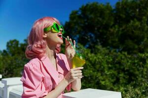 modisch Frau mit Rosa Haar Sommer- Cocktail erfrischend trinken Sommer- Tag foto