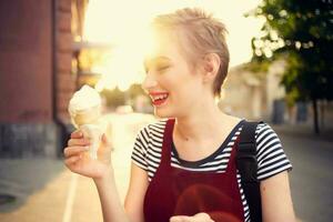 ziemlich Frau draußen Essen Eis Sahne Sommer- Sonne Entspannung foto