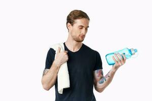 sportlich Mann im schwarz T-Shirt trainieren Wasser Flasche foto