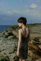 modisch Frau im Kleid auf Natur Felsen Landschaft draußen foto