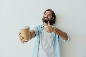 freiberuflich tausendjährig Mann mit ein Bart Trinken Kaffee von ein recycelt Tasse im stilvoll Hipster Kleider Weiß T-Shirt Blau Jeans und Hemd auf ein Weiß Hintergrund foto