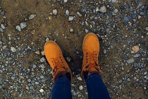 weiblich Füße im Stiefel auf das Boden Natur oben Aussicht foto