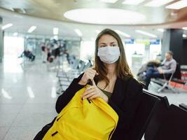 weiblich medizinisch Maske Flughafen Gelb Rucksack Passagier foto