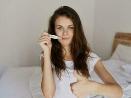 Frau mit ein Thermometer im ihr Mund positiv Temperatur foto