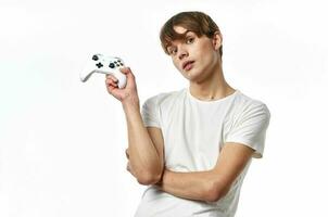 jung Kerl im ein Weiß T-Shirt Joystick im das Hände von das Spiel Emotionen Licht Hintergrund foto
