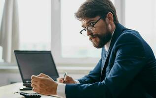 Mann im passen im Vorderseite von Laptop Büro Manager Finanzen foto