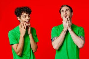 heiter freunde im Grün T-Shirts halt auf zu das Gesicht von Emotion foto