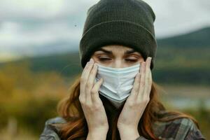 Frau im medizinisch Maske auf Gesicht geschlossen Augen Natur Hut Modell- foto