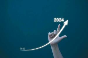 Geschäft planen und Strategie Konzept, Kind Hand Zeichnung Linie zum zunehmend Pfeil von 2023 zu 2024 zum Vorbereitung glücklich Neu Jahr Konzept. Neu Geschäft im Neu Jahre, Start oben foto