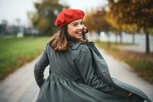 Porträt von ein glücklich Frau mit ein rot Baskenmütze foto
