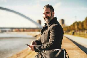 Mann ist Sitzung draussen im das Stadt und mit das Telefon. foto