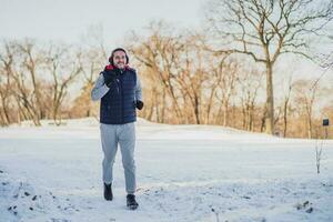 Erwachsene Mann ist Laufen auf das Park im Winter. foto