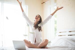 Frau mit Dollar-Banknote auf dem Bett foto