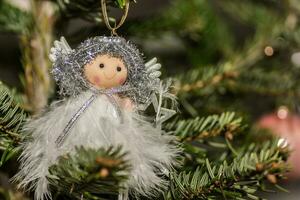 wenig nett Engel hängt auf ein Weihnachten Baum Detail foto