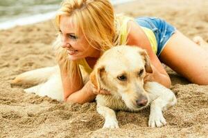 Frau mit Hund spielen auf das Strand foto