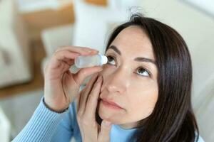 Frau mit Auge tropfen, Frau fallen lassen Auge Schmiermittel zu behandeln trocken Auge oder Allergie, krank Frau Behandlung Augapfel Reizung oder Entzündung Frau Leiden von gereizt Auge, optisch Symptome foto