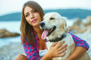 Frau mit ein Hund auf ein gehen auf das Strand foto