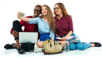 glücklich Studenten mit Bücher, Laptop, Taschen und macht Selfie auf Weiß Hintergrund foto