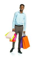 glücklich afrikanisch amerikanisch Mann halten Einkaufen Taschen auf Weiß Hintergrund foto