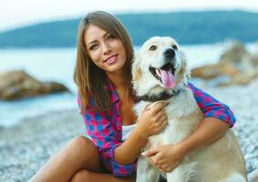 Frau mit ein Hund auf ein gehen auf das Strand foto