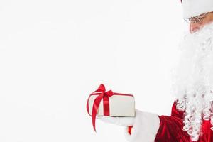 Weihnachtsmann in Gläsern, die Geschenkbox halten foto