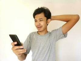 traurig Mann suchen beim seine Telefon Bildschirm foto