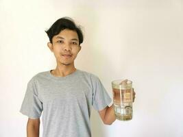 asiatisch Mann hat ein Glas von Wasser auf isoliert Hintergrund foto