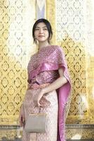 schön asiatisch Mädchen im thailändisch traditionell Kostüm beim Tempel foto