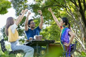 Eine Gruppe von College-Studenten trifft sich und arbeitet im Sommer draußen im Garten des Universitätscampus an Diplomarbeiten und Projekten foto