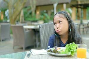 asiatisch Mädchen mit Ausdruck von der Ekel gegen Gemüse foto