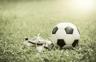 Fußball auf Gras und Zucht Schuh auf Jahrgang Ton foto