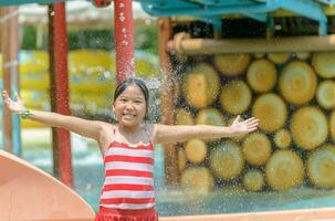 glücklich wenig kaukasisch Mädchen spielen Wasser beim Wasserpark foto
