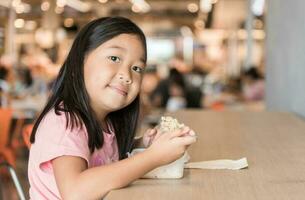 süß asiatisch Mädchen Essen Box Mittagessen im Essen Gericht foto