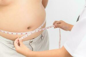 wenig Arzt Messung fettleibig Kind Taille Körper Fett isoliert foto