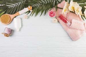 Handtuch mit Salz und Pinsel mit Blumen und Blättern auf Holzhintergrund foto