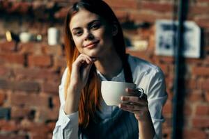 ziemlich Frau Bedienung Tasse mit trinken Cafe Backstein Mauer foto