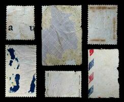 Sammlung von leer Jahrgang Porto Briefmarken mit anders Größe und Textur Variation isoliert auf schwarz Hintergrund. zurück Seite foto