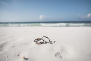 zwei Hochzeit Ringe im das Sand auf das Hintergrund von ein Strand und Meer. ai generiert foto