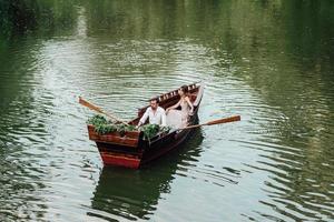 Eine Bootsfahrt für einen Mann und ein Mädchen entlang der Kanäle und Buchten des Flusses foto