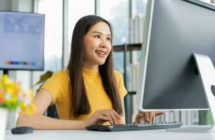 porträt glückliche junge asiatische programmiererin arbeitet im start-up-technologiebüro und verwendet computer zum codieren von anwendungsprogrammen und ist voll kreativ. Konzept der intelligenten Unternehmerin. foto