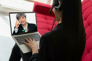 asiatisch Geschäftsmann Herstellung ein Video Anruf zu Kunde zum reden und präsentieren Arbeit durch das Video Konferenz. Konzept von virtuell Kommunikation Technologie Arbeiten zusammen foto