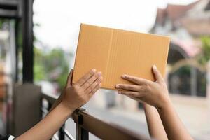 Post- Bedienung Senden Papier Karton Box zu Kunde im Vorderseite von ein Haus draussen. Versand Bedienung Ankunft und senden zu Kunde Adresse. foto