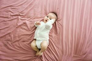 Bild von ein Neugeborene Baby Lügen auf ein Rosa Bett foto