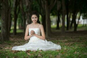 asiatisch Mädchen im Hochzeit Kleid im das Wald foto