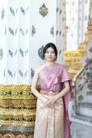 schön asiatisch Mädchen im thailändisch traditionell Kostüm beim Tempel foto