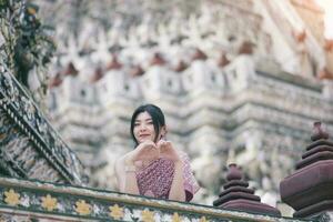 schön asiatisch Mädchen im thailändisch traditionell Kostüm beim Tempel foto