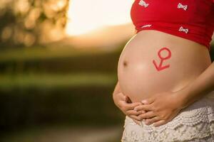 Bild einer schwangeren Frau, die ihren Bauch mit den Händen berührt foto