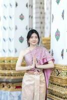 schön asiatisch Mädchen im thailändisch traditionell Kostüm beim Tempel foto