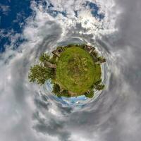 grüner winziger Planet im blauen Himmel mit schönen Wolken mit Transformation des sphärischen Panoramas 360 Grad. Krümmung des Raumes. foto