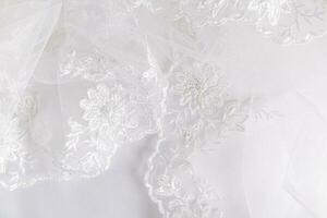 ein schick durchbrochen gestickt Fragment von ein Hochzeit Weiß Schleier mit Perlen und Perlen, mit Sanft Falten. Hochzeit Hintergrund. foto